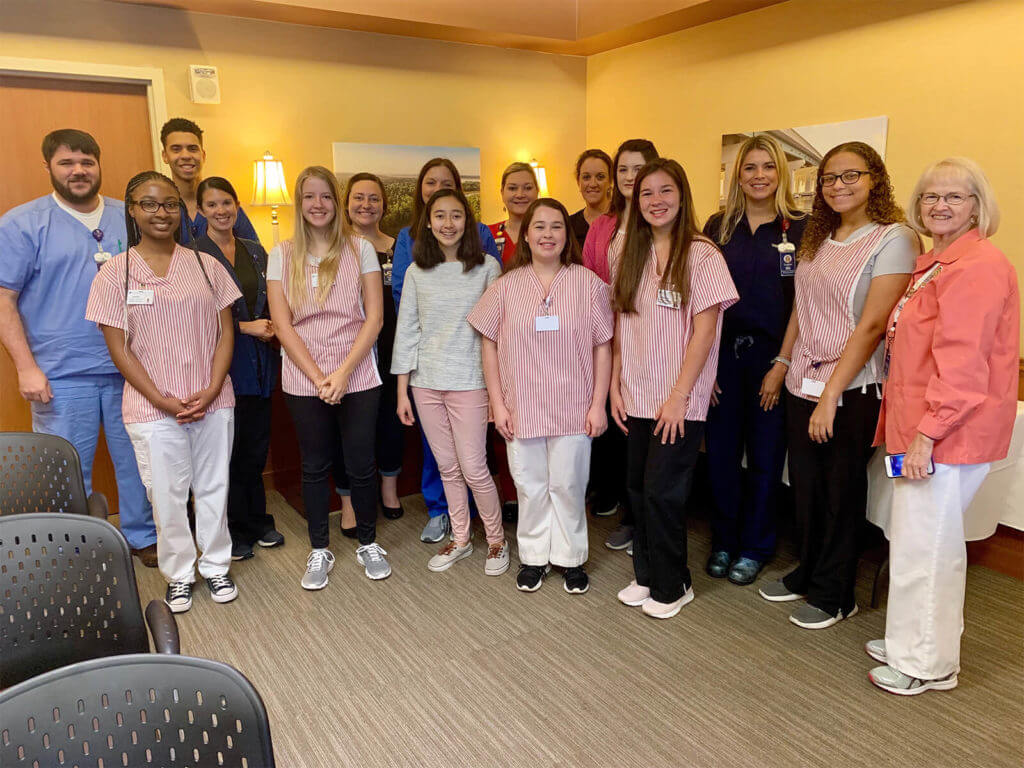 Summer student volunteers for Singing River Health System pose for a photo alongside hospital staff.