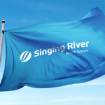 Waving flag with Singing River Health System logo displayed prominently